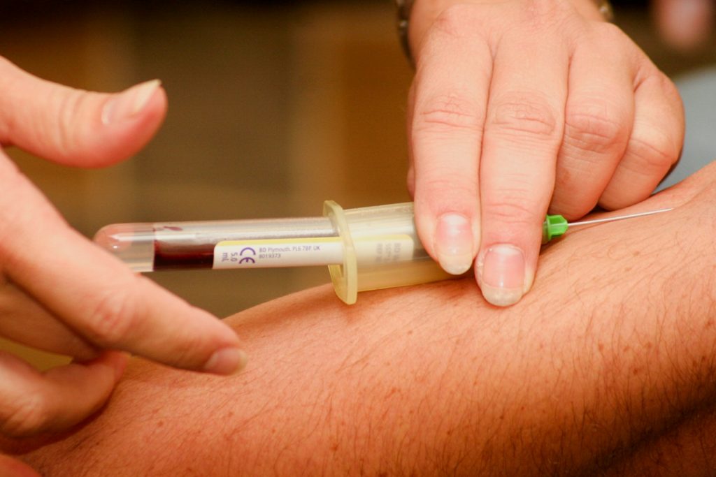 person injecting syringe;